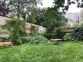 Mobilier de jardin sur la pelouse avec les massifs arbustifs en bordure