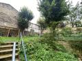 Le jardin est surélévé, vue de l'escalier et du talus végétalisé, l'abri à vélos se situe en arrière plan