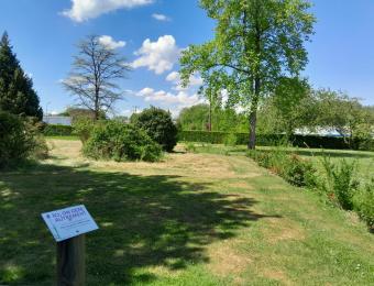Fauche différenciée accompagnée par un panneau pédagogique et sur la droite, une haie champêtre plantée avec les élèves